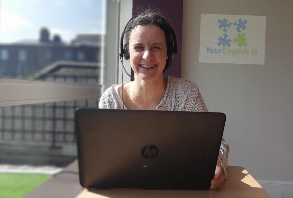 A female English teacher smiling and looking directly at the camera